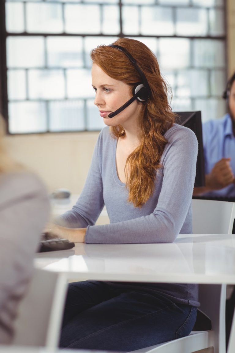 Concentrated female operator with headset in office
